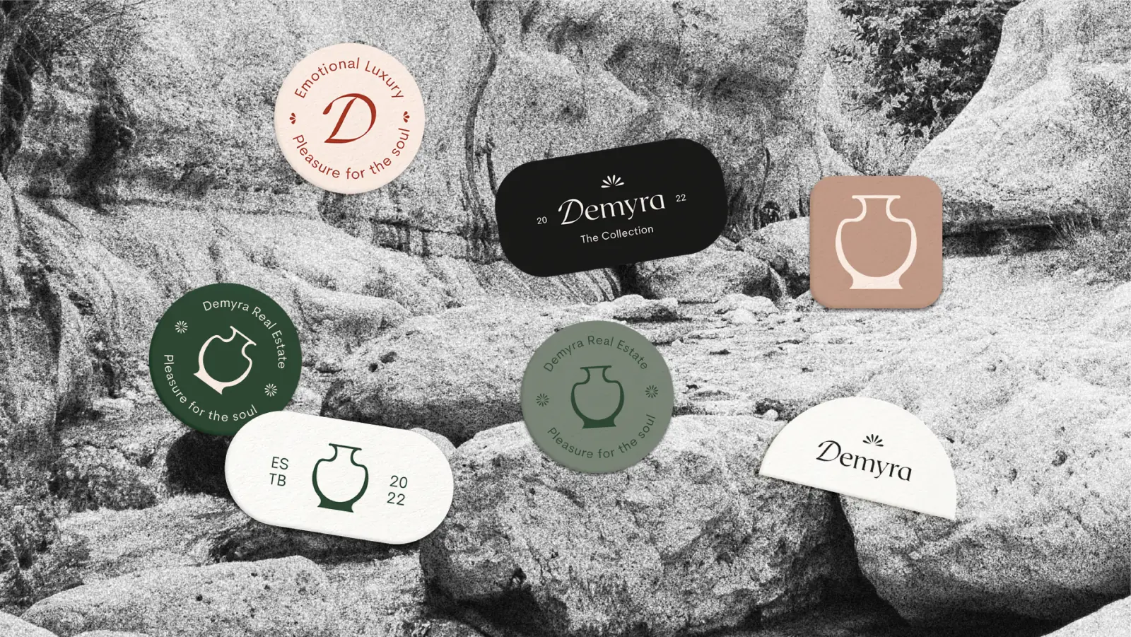 Demyra badges and stickers in green, blush and cream laid over rocks